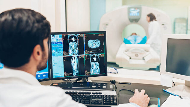 Doctor looking at a monitor with patient's MRI scan results