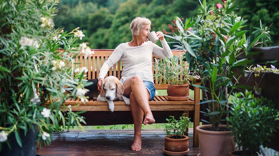 Women drinking coffee on her deck with her dog