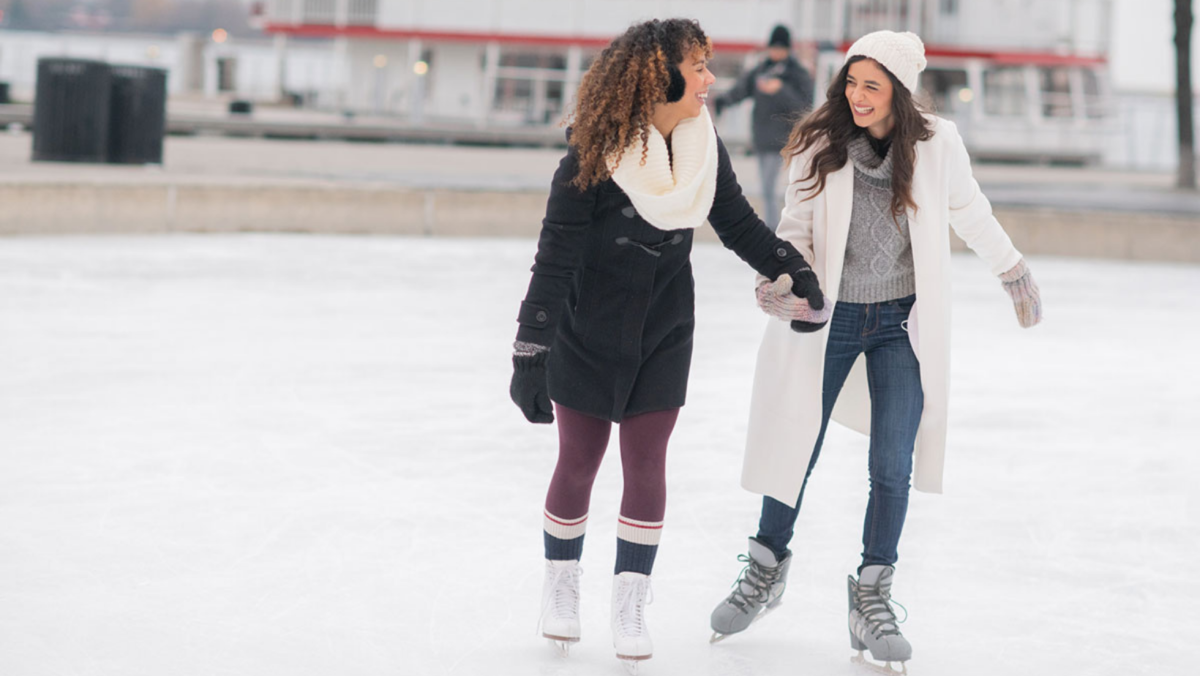 Two female friends ice skating